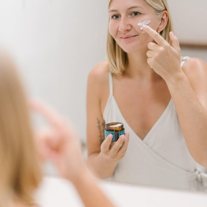 Een vrouw brengt crème aan op haar gezicht met Hydraterende Dagcrème met Hyaluronzuur